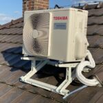 Venkovní jednotka klimatizace Toshiba upevněná na konstrukci na šikmé taškové střeše